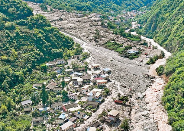 山洪泥石流災害現場，滿目受損的民房和道路。（中新社圖片）