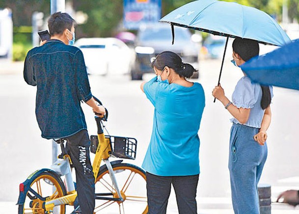 深圳發布高溫黃色預警，民眾酷暑下出行。（中新社圖片）