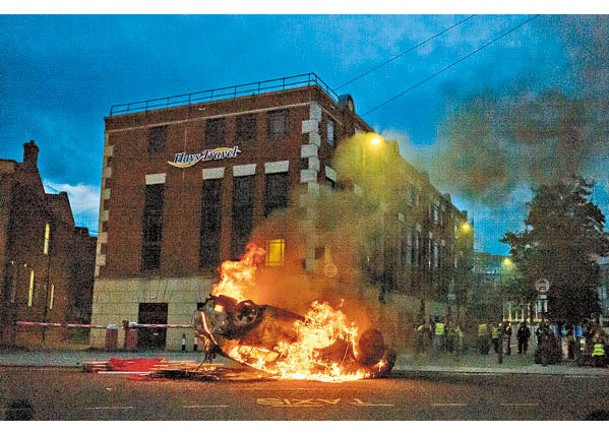 示威人士掀翻汽車並放火。
