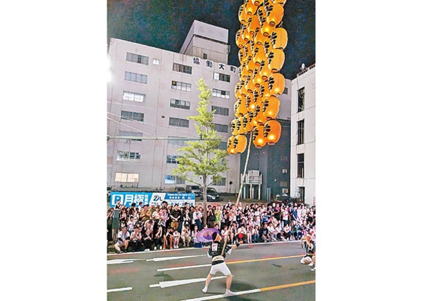 撐竿人在街道上高舉竿燈，表演各種絕技。