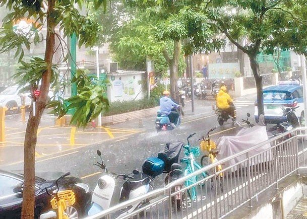 深圳多區有狂風暴雨，外賣員電單車涉水而行。