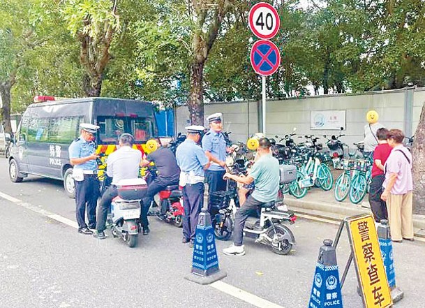 交警抽查違規電動自行車駕駛者。