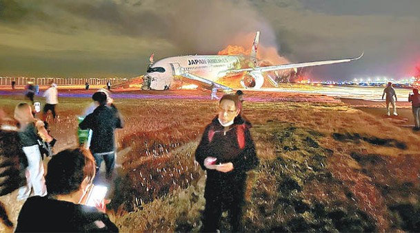 日航客機乘客慌忙逃生。