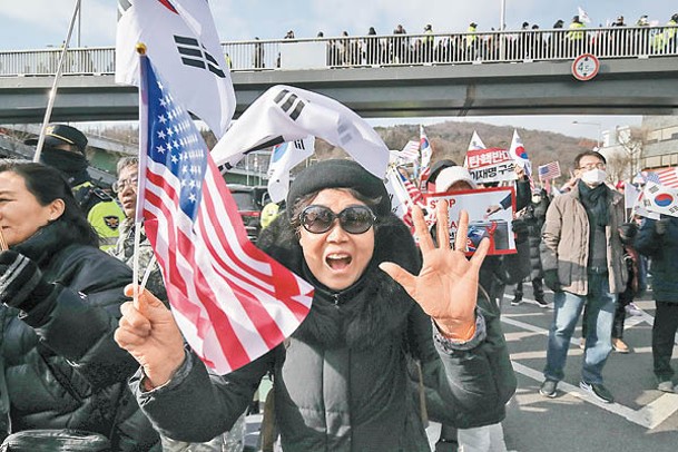 尹錫悅的支持者手持韓美國旗，在總統官邸附近抗議彈劾。（Getty Images圖片）