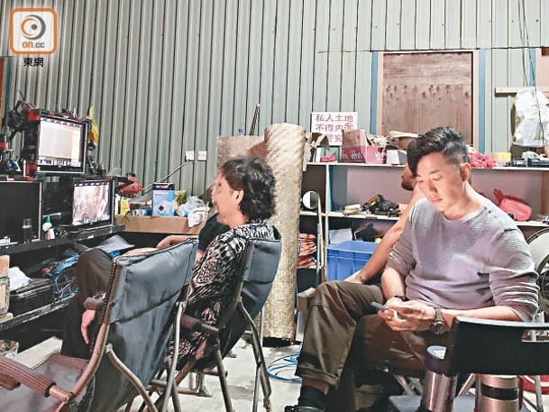 完成拍攝後，劉青雲（左）與劉浩龍睇Playback及稍作休息。
