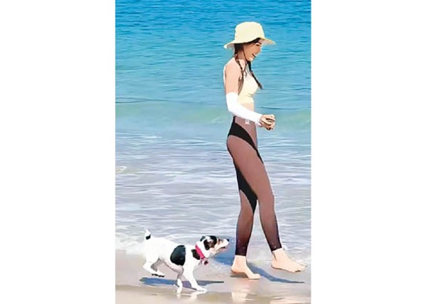 Amber與狗狗在海邊與陽光玩遊戲。