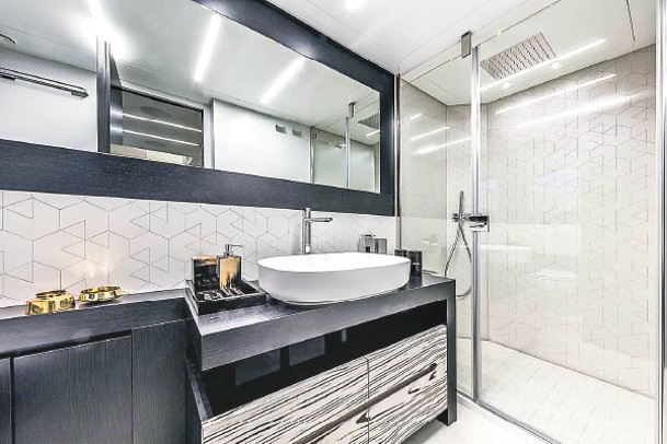 浴室以白色為主調，搭配黑色木紋櫃。