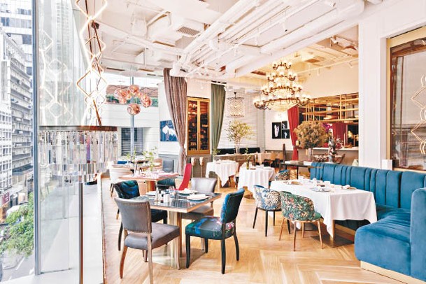 華麗吊燈配上色彩繽紛的餐桌和椅子，加上落地玻璃，光猛開揚，營造出時尚貴氣氛圍。