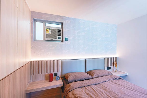 顏色上淺下深的入牆衣櫃，既可以儲物，亦可以減低視覺上的壓迫感，床頭的燈槽與木條則呼應全屋設計風格。