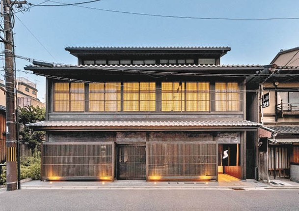 The Shinmonzen外牆是深色的木製立面，屋頂則是弧形的日式瓦片，充滿傳統風情。