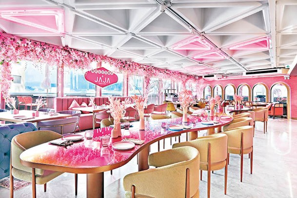 粉紅區域布滿花卉擺設，中央的波浪形餐枱，貫穿整間餐廳。
