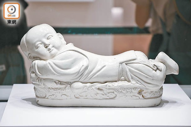 白釉孩兒枕來自北宋時期，由當時「五大名窯」之一的定窯所製作。