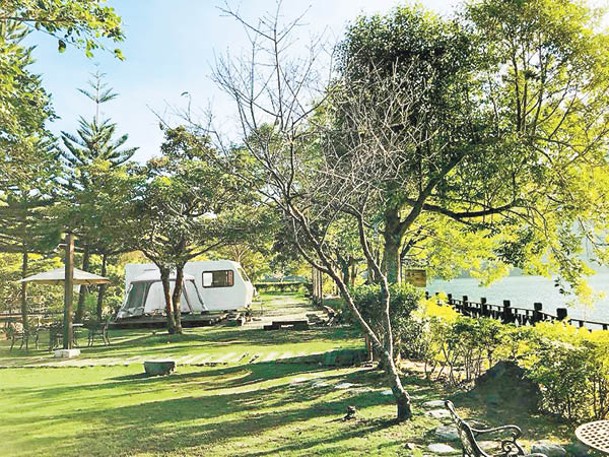 露營車在湖邊停泊，還有加設上蓋的戶外用餐區。