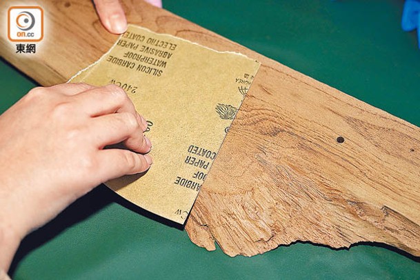 先打磨木材的粗糙表面，再用砂紙左右磨擦。