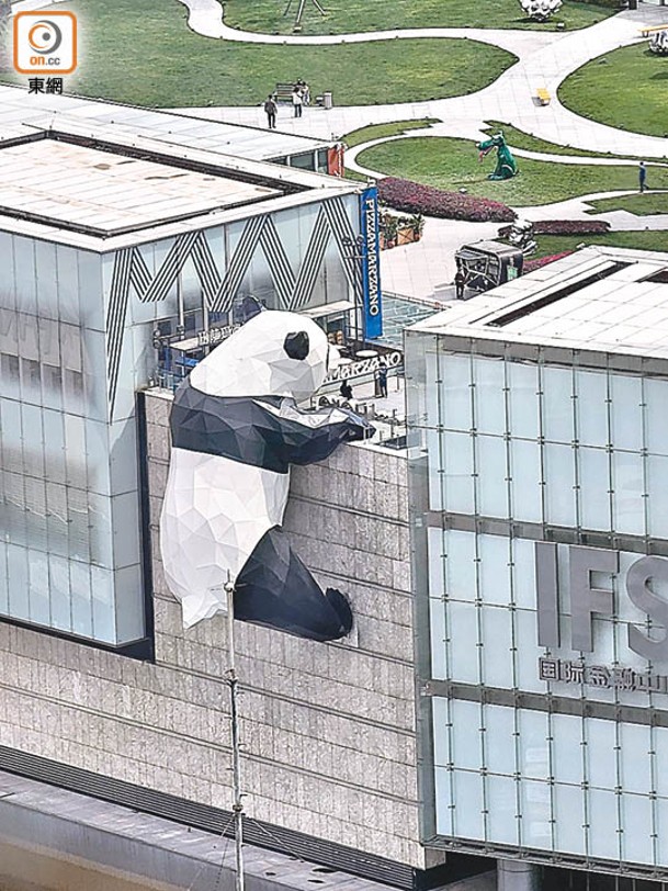 高15米的熊貓裝置恍如在建築外牆攀爬，輕易吸引周邊途人目光。
