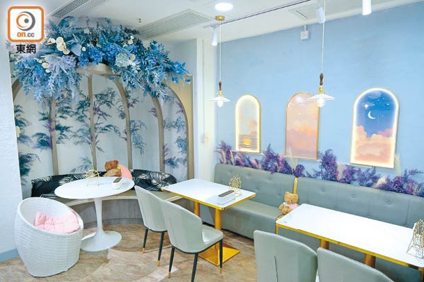 Café一邊有巨型鳥籠裝飾座位，粉藍色牆上掛上夢幻的風景畫。
