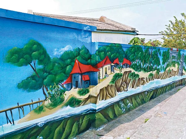 村屋外牆漆滿不同風格的壁畫，這一幅將新界東北的特色建築融入其中，出自德國青年畫家Karl之手。（相IG：ben_yuen_w_y）
