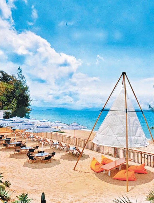 太陽傘與沙灘椅一字排開，旁邊的三角帳篷相當有特色。