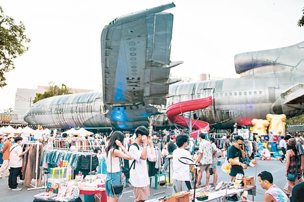 機翼下的大片空地逢周二至日都會擺滿攤檔，搖身一變成熱鬧的「飛機夜市」。