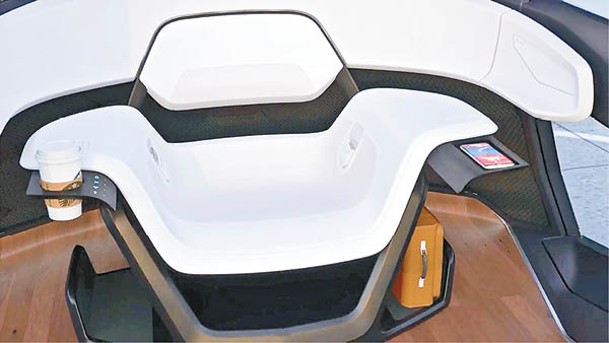 座椅底部兩側設有置物架，一對扶手分別內藏伸縮智能手機托板、杯架及手勢操控的生物識別使用者介面等。