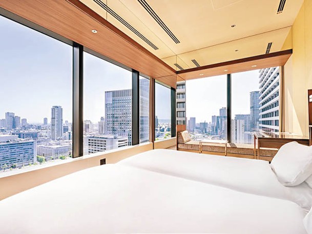 酒店客房採用典雅米白色和木質調設計，玻璃窗更伸延至天花。