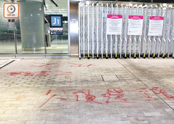 高鐵西九龍站J1出口地上被噴上欠債還錢等字句。（楊日權攝）
