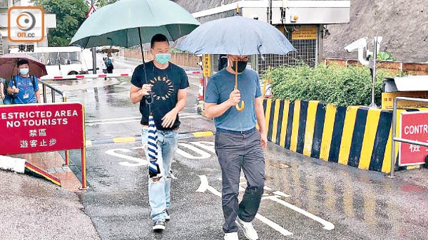 黎見恩（右）和黎耀恩（左）冒雨探訪父親。（吳鎮興攝）