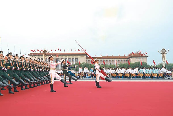 解放軍持五星旗前往升旗區。（中新社圖片）