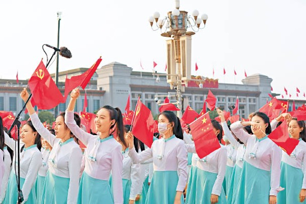 由中學生組成的合唱團在揮舞旗幟。