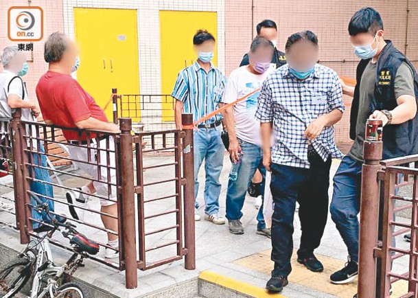 荃灣：被捕男子由警員押走。
