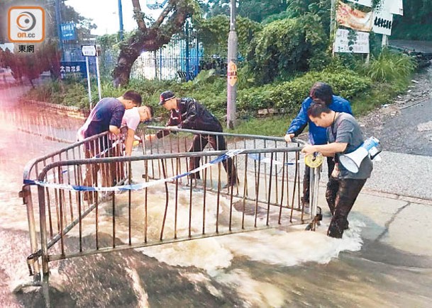 豪雨下錦田公路路陷，警員把有關位置圍封。