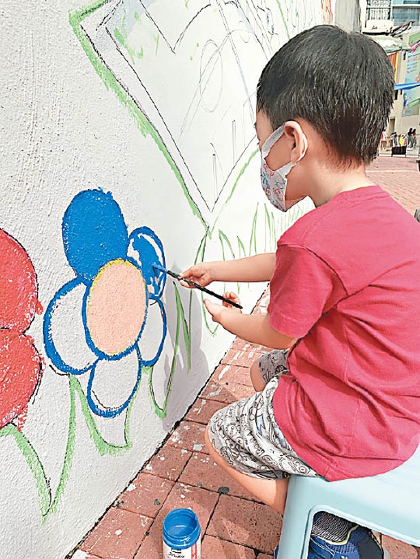 小朋友用心地粉飾荃灣區少年警訊會所外牆。
