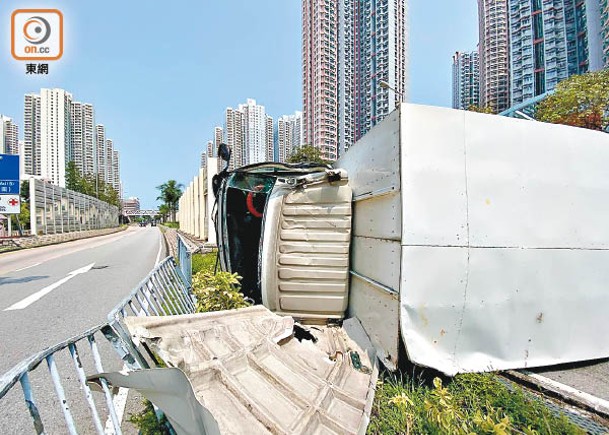 貨車撞欄後翻側，車身鐵皮損毀。（曾志恒攝）