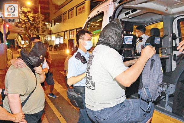 中環：涉案兩名超市職員由警員帶上警車。（李國健攝）