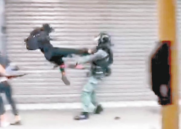 案發期間，一名黑衣人起飛腳踢軍裝警員。