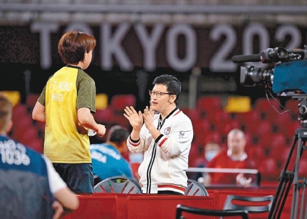 乒乓球港隊教練陳栩（右）臨場指導。