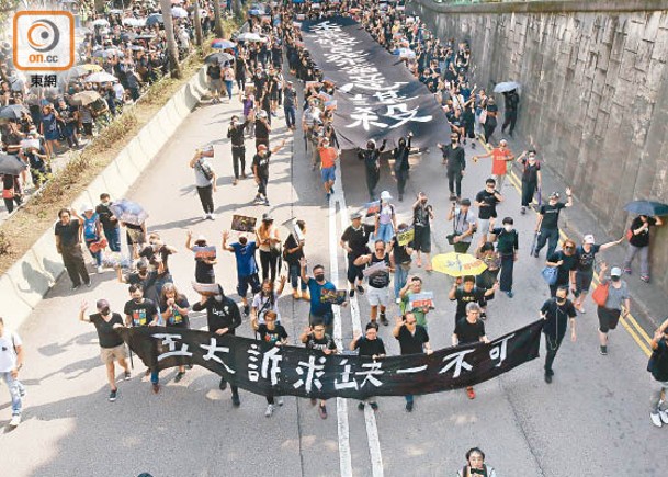 梁國雄（前排左三）等人聚集在尖沙咀高舉橫額遊行。