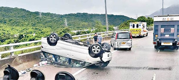 七人車撞欄後翻轉。