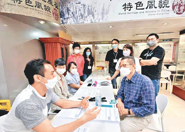 財政司司長陳茂波（前右）到訪消費券服務點了解運作情況。