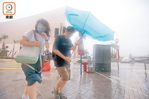 尖沙咀：市民外出，所持雨傘被強風吹至變形。