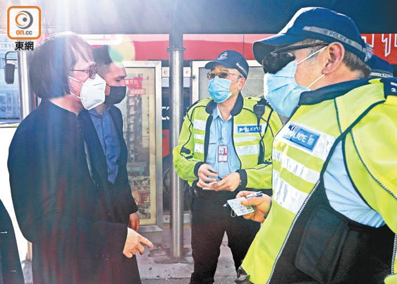 上海仔（左）亂過馬路遭票控，交通警手執其身份證。