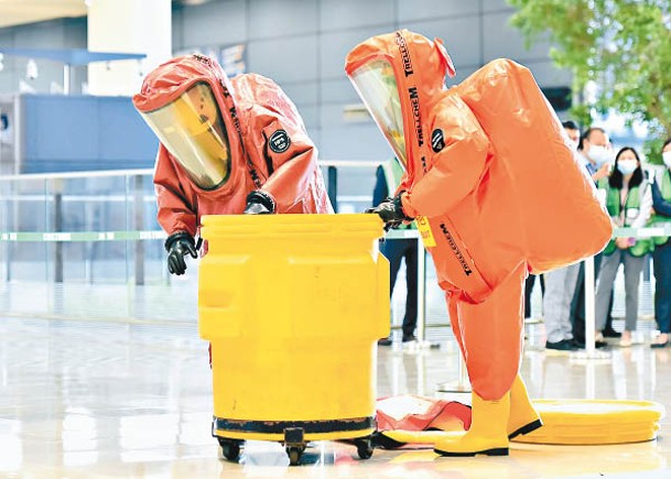 穿着化學物品保護袍的消防處人員於現場處理危害物質。
