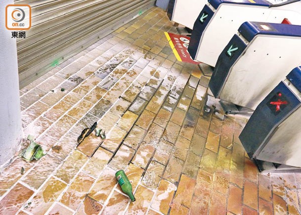 事發後，九龍塘站閘機旁遺下玻璃樽。