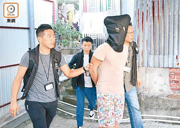 案發後，警員押解男被告蕭國偉到涉案居所搜證。