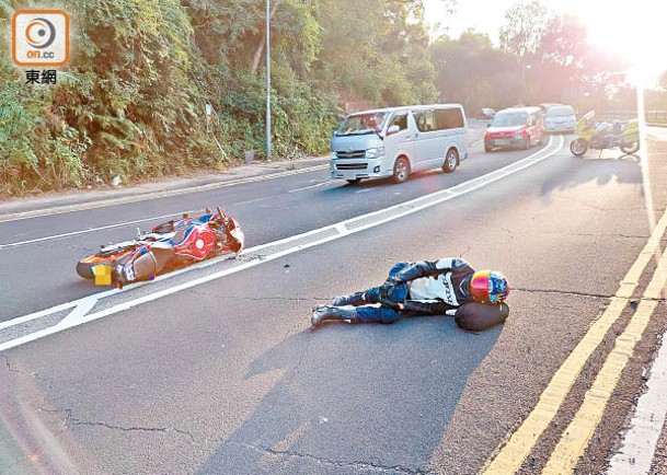 大埔公路：意外後鐵騎士倒臥地上待援。（張開裕攝）
