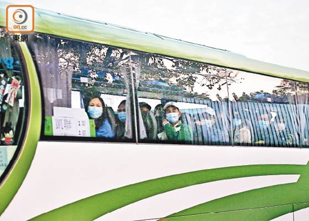 旅遊巴士載有多名人士，駛離竹篙灣檢疫中心。（胡家豪攝）