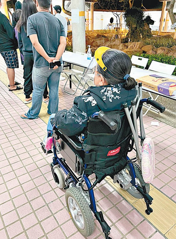 陳先生推着需要坐輪椅的年邁母親到樓下強檢，批評資訊不透明令居民恐慌。