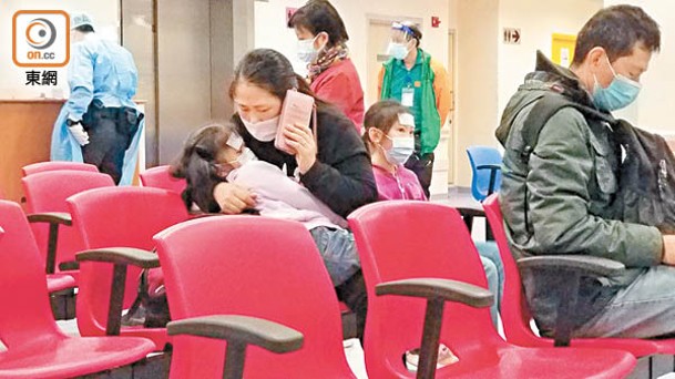 在明愛醫院急症室，焦急的母親一邊照顧發燒的女兒，一邊打電話求援。