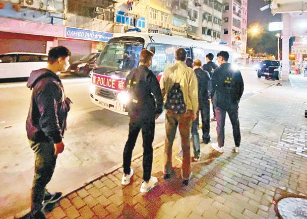 九龍城：被捕男子由探員押上警車。