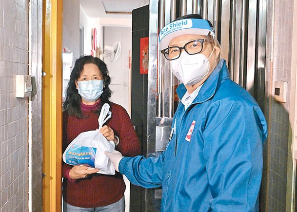 鄧炳強（右）派發「防疫服務包」給區內一個家庭。